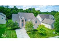 Beautiful two-story brick home featuring a manicured lawn and a welcoming blue entryway at 7212 Maple Bluff Pl, Indianapolis, IN 46236