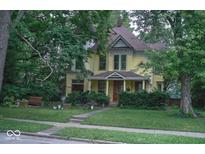 Charming two-story home with well-manicured landscaping and inviting front porch at 783 Woodruff Place Middle Dr, Indianapolis, IN 46201