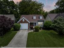Charming home with a well-manicured lawn, brick accents, and an attached garage at 9700 River Oak E Ln, Fishers, IN 46038