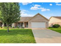 Charming brick home featuring a well-manicured lawn, two-car garage, and inviting front porch at 1056 Hilltop Commons Blvd, Whiteland, IN 46184