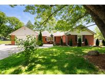 Charming red brick home featuring a well-manicured front yard with mature trees and a cozy front patio at 106 N Jamalee Way, Pendleton, IN 46064
