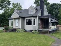 Charming single-Gathering home with gray siding, a chimney, and a well-manicured lawn at 114 S Green St, Brownsburg, IN 46112