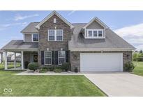 Charming two-story brick home featuring a well-manicured lawn and attached two car garage at 1215 W Curry Rd, Greenwood, IN 46143