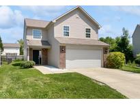 Two-story home featuring vinyl siding, a brick facade, an attached two car garage and a well-maintained front lawn at 1525 Bluestem Dr, Greenwood, IN 46143