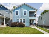 Charming two-story home with light blue siding, a small porch, and a well-maintained front yard at 422 Sanders St, Indianapolis, IN 46225