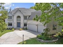 Stunning two-story white brick home with a three-car garage and a well-manicured front yard at 4763 Woods Edge Dr, Zionsville, IN 46077
