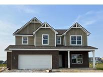 New two-story home boasts a brick-and-siding facade, attached garage, and gabled roof under a clear blue sky at 5002 Amber Wood Dr, Lawrence, IN 46235