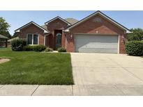 Charming brick home featuring a two-car garage and a well-maintained front lawn at 5148 Constitution Ct, Columbus, IN 47203