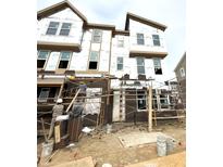 Exterior view of a new three-story home in progress with brickwork and building wrap at 7333 Bayview Run, McCordsville, IN 46055