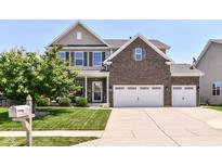 Charming two-story home with a manicured lawn, brick accents, and a three car attached garage at 7733 Chestnut Eagle Ct, Zionsville, IN 46077
