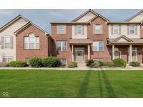 Charming brick townhouse with a well-manicured lawn and inviting front entrance at 8425 Codesa Way, Indianapolis, IN 46278