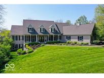 Stately home with manicured lawn, black shutters and columns, and mature trees under a clear sky at 10707 Club Chase, Fishers, IN 46037