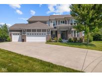 Charming two-story home boasts a three-car garage, a brick facade, and a beautifully landscaped front yard at 15047 Glenmoor Cir, Carmel, IN 46033