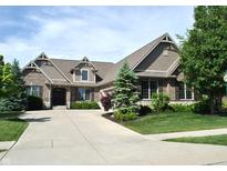 Stunning brick home featuring manicured landscaping, mature trees, and a long driveway at 16550 Gleneagles Ct, Noblesville, IN 46060