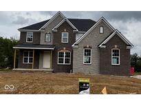New two-story home featuring a brick and stone facade with a covered porch and large windows at 1919 Delp Ct, Avon, IN 46123