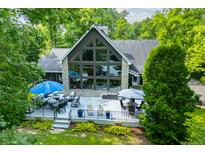 Stunning lake house featuring a large deck, floor to ceiling windows, and well-maintained landscaping at 3695 Windsor Pl, Martinsville, IN 46151