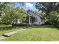 Charming home with a well-maintained lawn and cozy screened front porch perfect for enjoying the outdoors at 6125 Winthrop Ave, Indianapolis, IN 46220