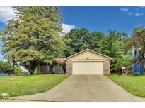 Charming brick home with an attached two-car garage and a concrete driveway at 7583 Rogers Dr, Indianapolis, IN 46214