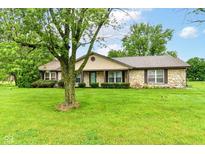 Charming stone-clad ranch home featuring a spacious front yard with mature trees and lovely landscaping at 9608 Sycamore Rd, Carmel, IN 46032