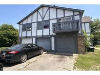 Two-story townhouse with a garage and dark trim detailing on a sunny day at 9794 Kingscross Ct, Indianapolis, IN 46235