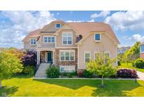 Charming two-story home with a combination of stone and siding and a well-manicured lawn at 10555 Serra Vista Pt, Fishers, IN 46040