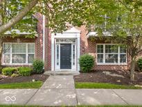 Charming red brick home featuring a black front door with white trim and manicured landscaping at 11509 Reagan Dr, Fishers, IN 46038