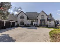 Elegant brick home featuring a circular driveway and manicured front yard landscaping at 11931 Promontory Ct, Indianapolis, IN 46236