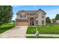 Charming two-story home featuring a landscaped front yard, brick facade, and attached two-car garage at 2434 Burgundy Way, Plainfield, IN 46168