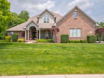 Charming brick home featuring a well-manicured lawn and inviting covered porch at 312 Hawthorne Dr, Pittsboro, IN 46167