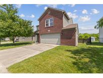 Charming two-story home featuring a brick facade, attached garage and well-maintained lawn at 3349 Capsella Ln, Indianapolis, IN 46203