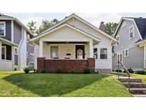 Charming bungalow with a brick foundation, inviting front porch, and well-maintained lawn at 4137 Rookwood Ave, Indianapolis, IN 46208