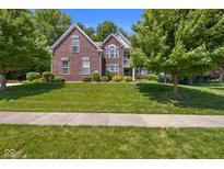 Charming two-story brick home with a well-manicured lawn and mature trees, creating curb appeal at 6524 Turning Leaf Ln, Indianapolis, IN 46236
