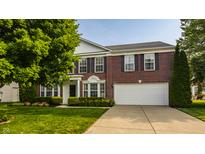 Charming two-story brick home with a well-manicured lawn and a two-car garage at 10248 Noble Ct, Indianapolis, IN 46234