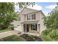 Charming two-story home features a well-maintained lawn, flower beds, and an attached two-car garage at 10510 Mcclain Dr, Brownsburg, IN 46112