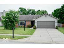 Charming single-story home with a well-maintained lawn, attached garage and brick details at 12157 Longstraw Dr, Indianapolis, IN 46236