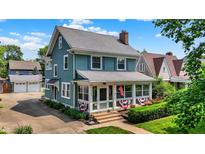 Charming two-story home with a welcoming front porch and well-maintained landscaping and a detached two car garage at 140 W Hampton Dr, Indianapolis, IN 46208