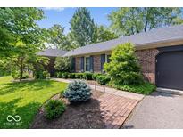 Well-maintained brick home with lush landscaping, a brick walkway, and a two-car garage at 1408 126Th St, Carmel, IN 46033
