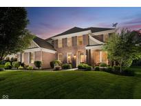 Elegant brick home with manicured lawn and lush landscaping, perfect for sophisticated living at 14662 Woodstone Cir, Fishers, IN 46037