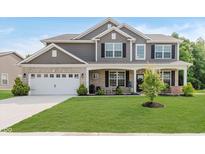 Beautiful two-story home featuring a well-maintained lawn, inviting front porch, and attached two-car garage at 1715 Foudray S Cir, Avon, IN 46123