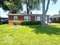 Charming brick ranch home featuring a well-manicured lawn and mature shade trees at 1820 Martin St, Indianapolis, IN 46237
