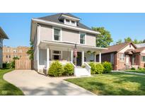 Charming two-story home with a inviting front porch, manicured lawn, and a curved driveway at 22 N Bolton Ave, Indianapolis, IN 46219