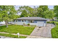 Charming single-story home features a well-maintained front yard, driveway, and beautiful trees at 3414 Ferncliff Ave, Indianapolis, IN 46227