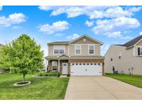 Charming two-story home with a brick-and-vinyl facade, well-manicured lawn, and attached two-car garage at 3811 Tartan Trl, Whitestown, IN 46075