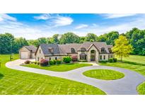 Stunning home with lush landscaping, circular driveway, and beautiful architectural details at 4181 Whitetail Woods Dr, Bargersville, IN 46106
