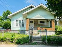 Charming home featuring a white front door, brick accents, and a well maintained front yard at 547 N Livingston Ave, Indianapolis, IN 46222