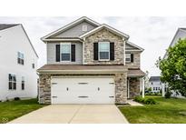 Charming two-story home featuring stone accents, a gray siding, and a two-car garage at 6114 Pebblebrooke Rd, Whitestown, IN 46075