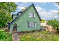Unique green home features a distinct, charming architectural design and well-kept lawn at 715 Kessler Blvd E Dr, Indianapolis, IN 46220