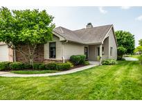 Charming home with a well-manicured lawn, mature trees, and inviting brick accents enhancing its curb appeal at 8223 Thoroughbred Run, Indianapolis, IN 46256