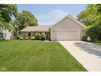 Charming single-story home featuring a well-maintained lawn, manicured landscaping, and an attached two-car garage at 9363 Hadway Dr, Indianapolis, IN 46256