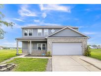Charming two-story home featuring gray siding, a brick accent wall, and a two-car garage at 9692 Centennial Ct, Avon, IN 46123